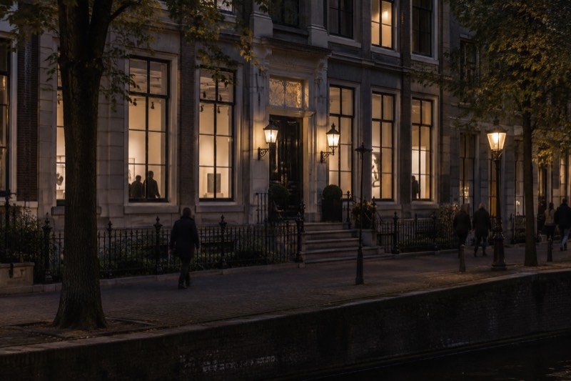 A grand nineteenth-century townhouse with tall windows and a small railed front garden, now a small modern-art museum, seen from the pavement opposite, Amsterdam, Netherlands