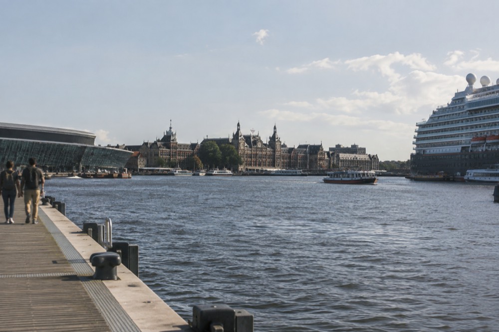 The IJ waterfront in Amsterdam with the cruise terminal building and Centraal station beyond