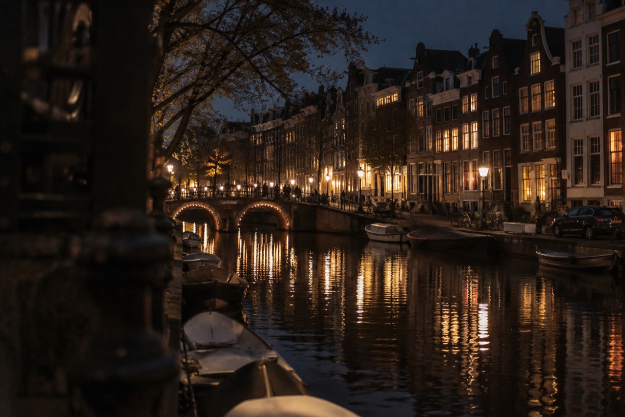 A canal in Amsterdam with narrow gabled houses reflected in the water