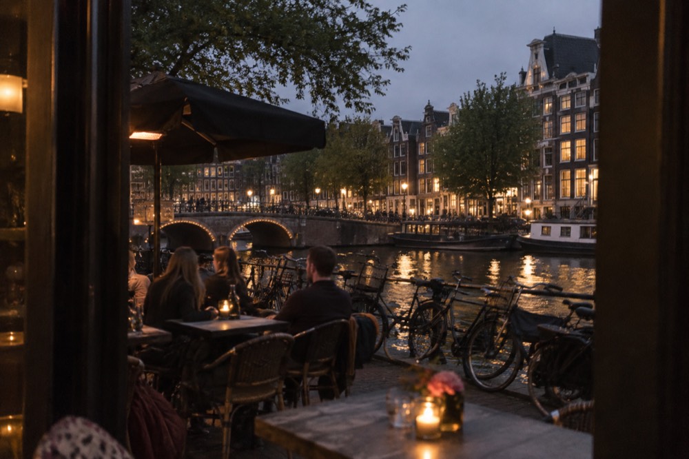 Canal-side restaurant terrace with bikes parked along the water
