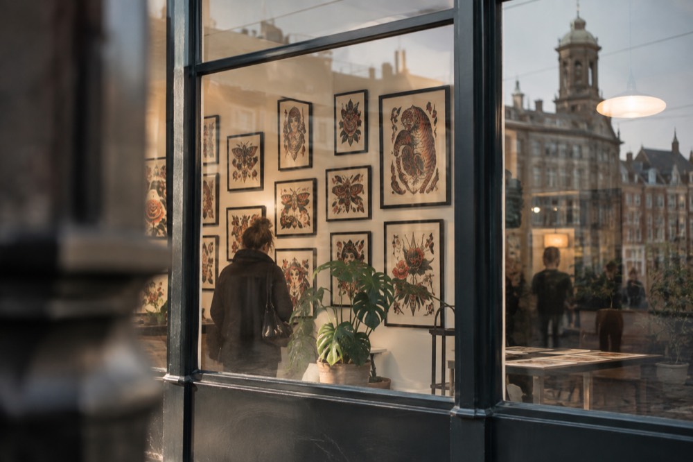 Framed tattoo flash artwork hanging on the wall of a bright gallery space