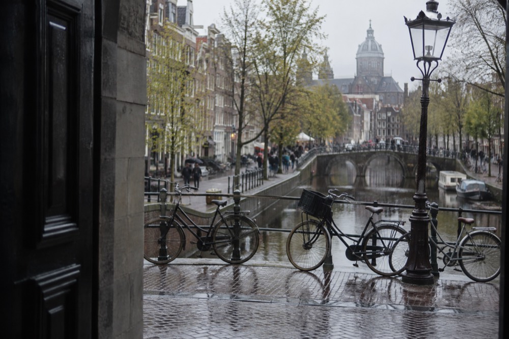 Bicycles parked on a stone bridge over an Amsterdam canal in the city centre
