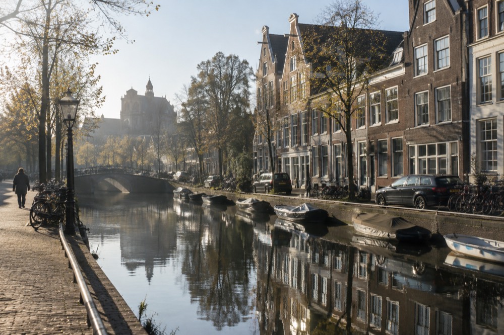 A canal in the Haarlemmerbuurt with narrow gabled houses reflected in the water