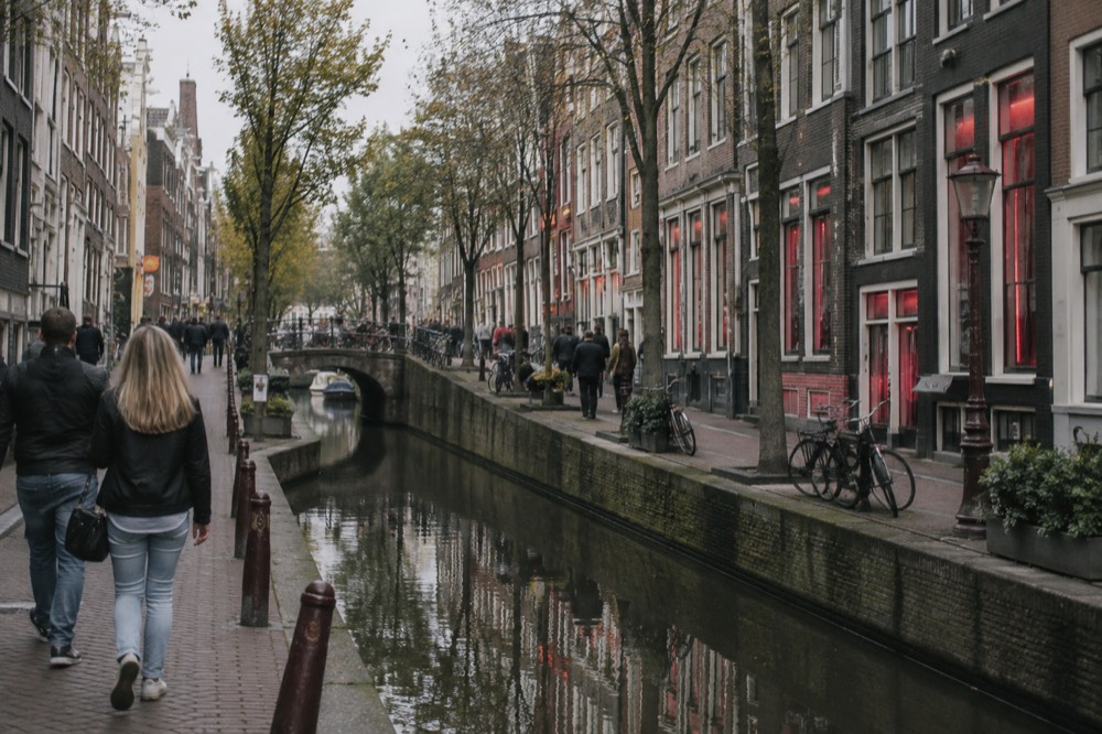 People walking past Red Light District, seen from across the street