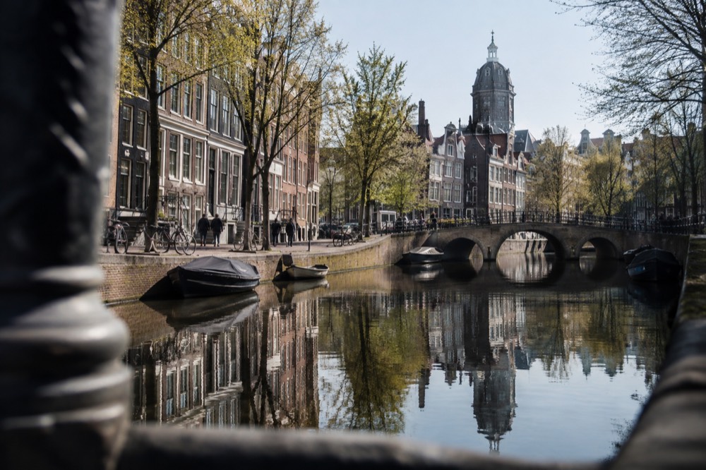 Reflection of 17th-century canal houses in a still Amsterdam canal