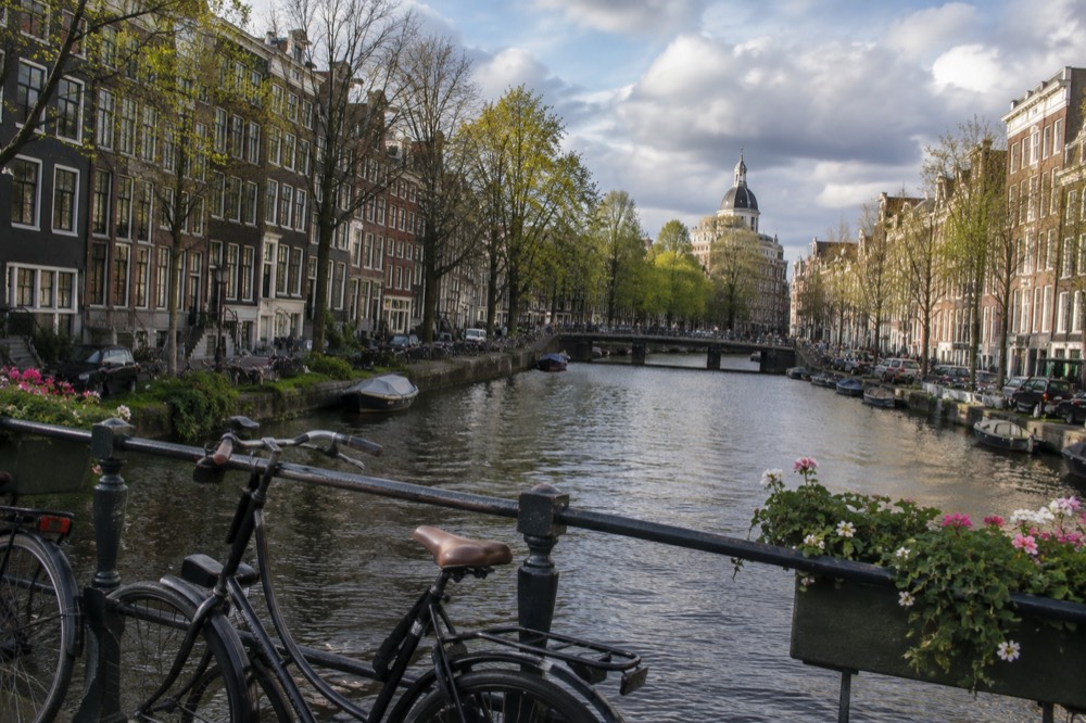 A quiet corner of Dam Square with trees overhanging the water