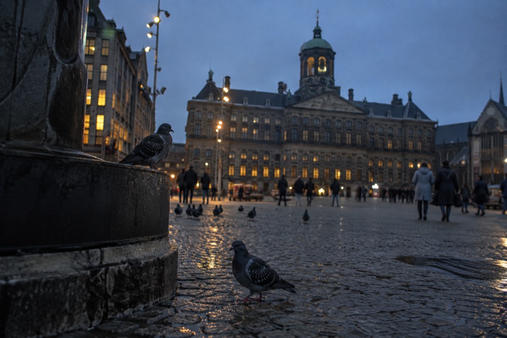 People walking past Dam Square, seen from across the street