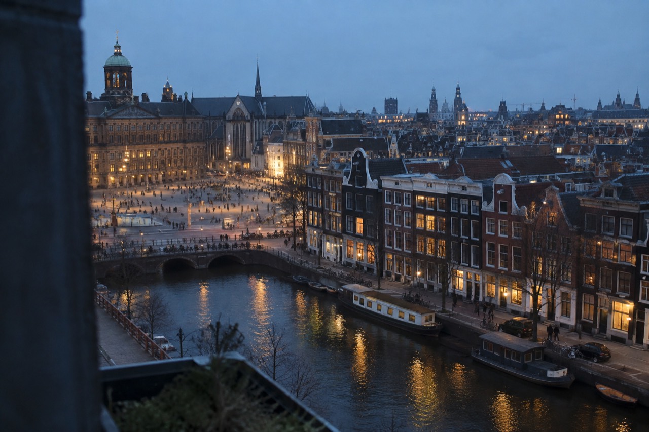 Aerial view of Amsterdam's historic canal ring, with colourful gabled houses reflected in the water