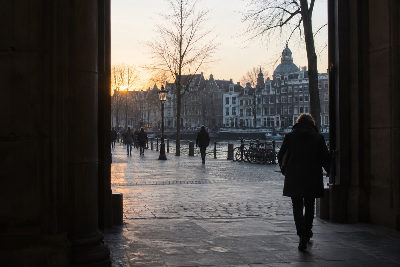 The canal-side street outside a museum entrance in central Amsterdam at dusk