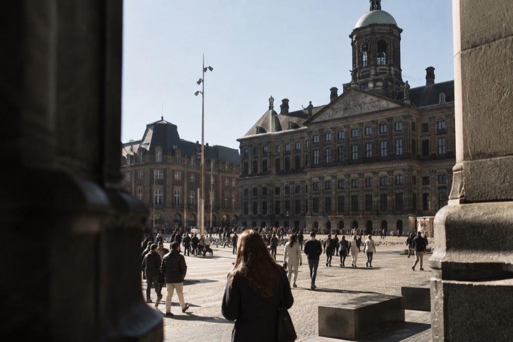 People walking past Dam Square, seen from across the street