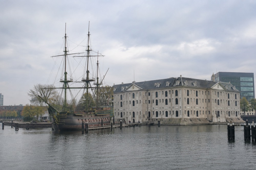 A tall ship moored at the quay beside the National Maritime Museum with the modern library building beyond