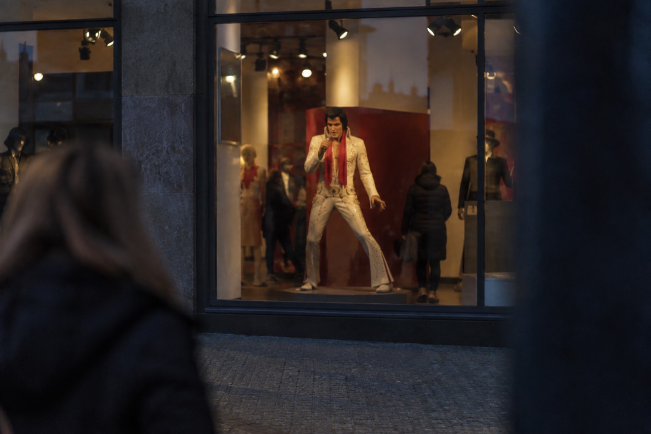 Wax figure of a famous singer displayed in a brightly lit museum gallery