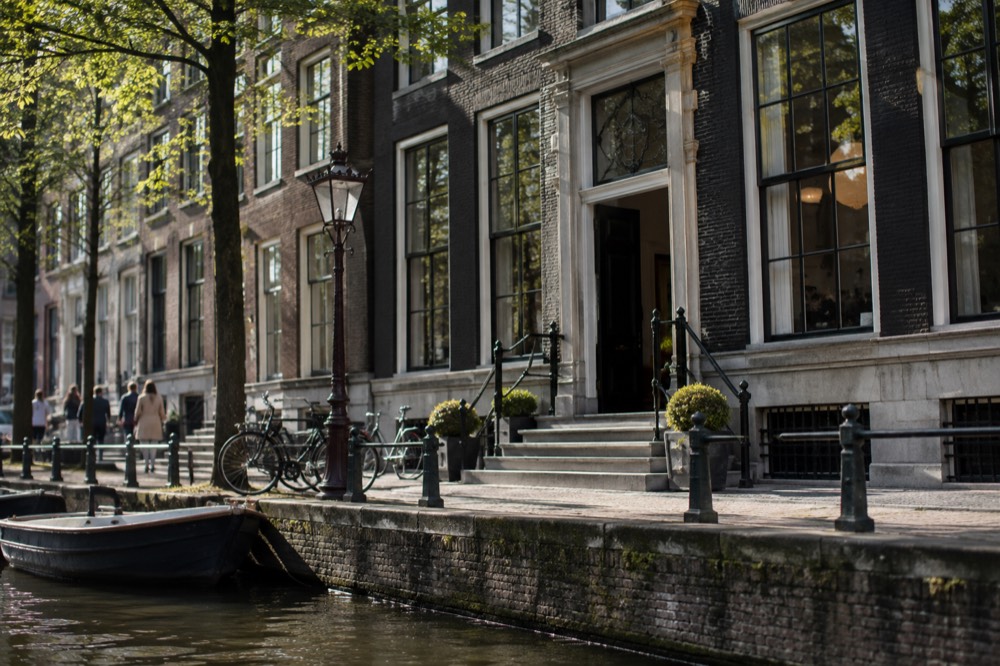 A gabled canal house facade on the Herengracht with the museum entrance doorway