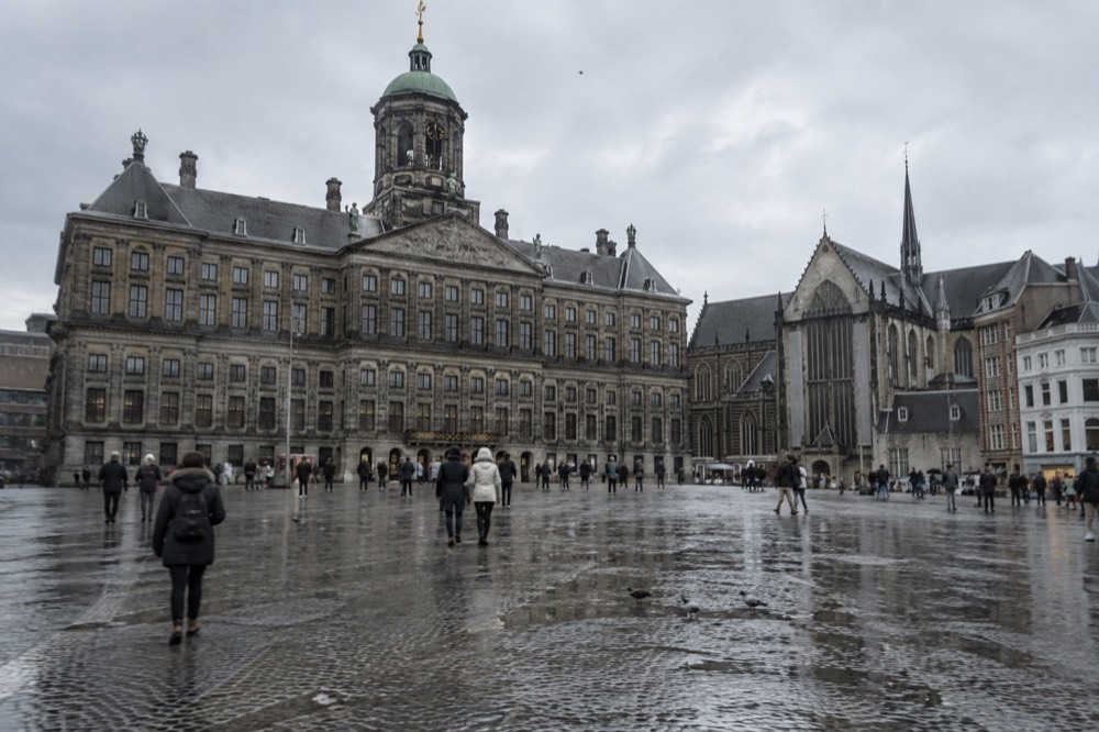 The waterfront near Dam Square under a broad grey northern sky