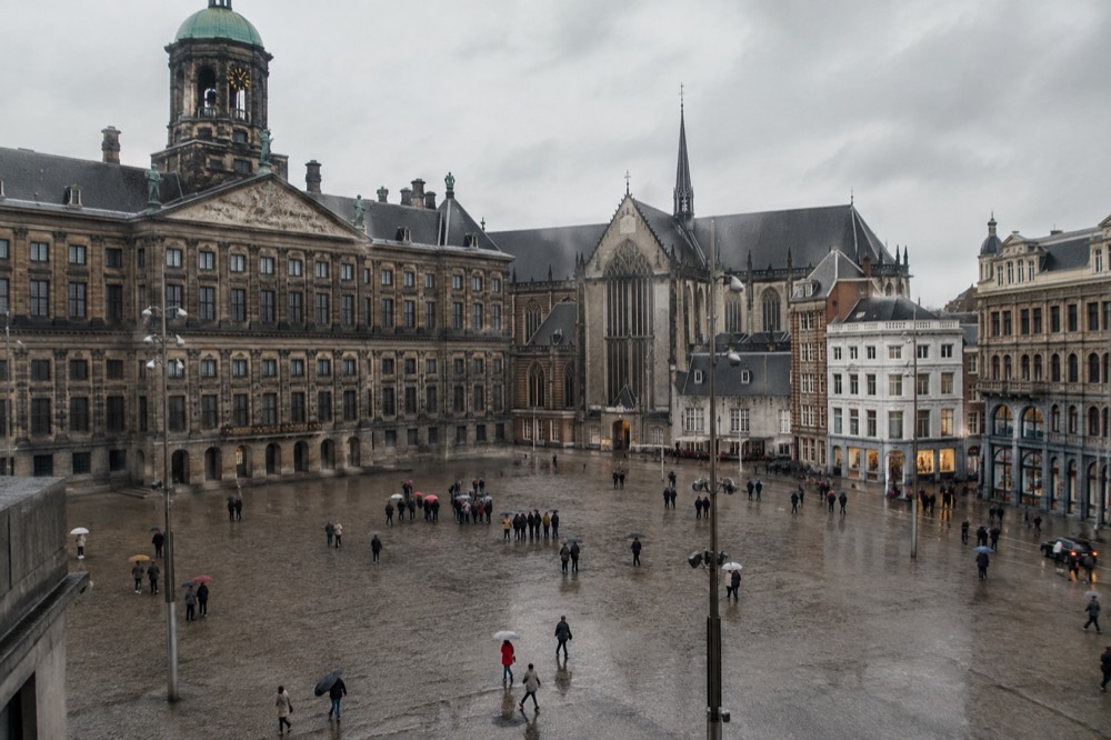 A quiet corner of Dam Square with trees overhanging the water