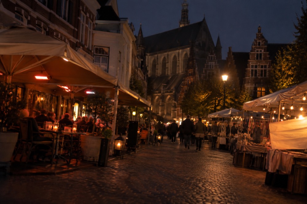 Café terraces and market stalls on a cobbled street in Haarlem