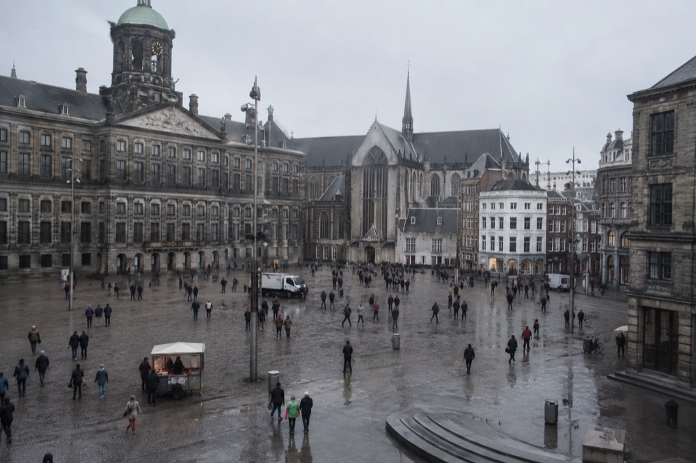 A quiet corner of Dam Square with trees overhanging the water