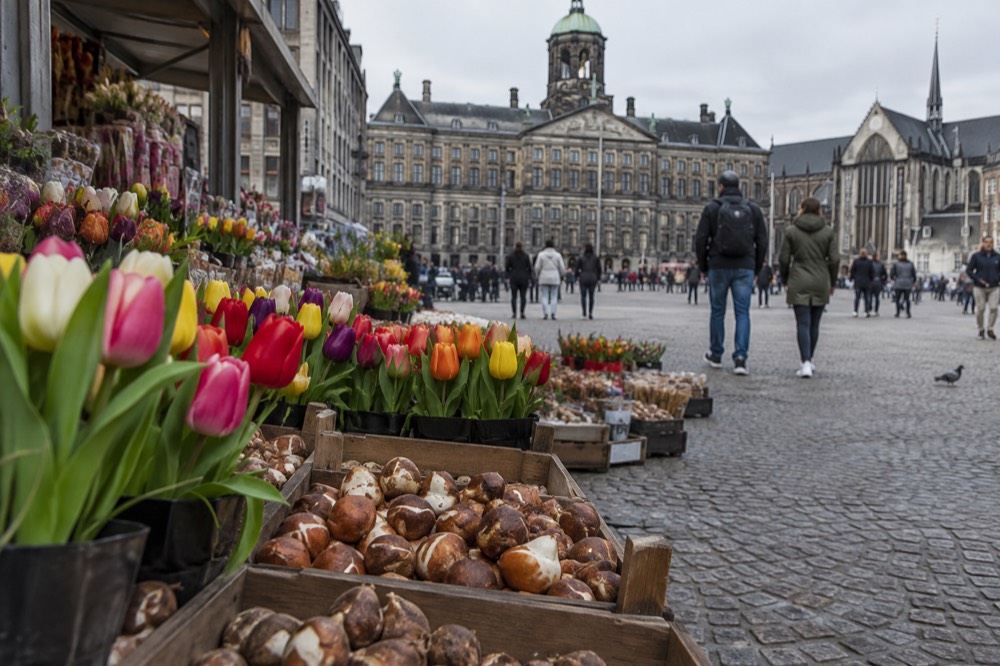 People walking past Dam Square, seen from across the street