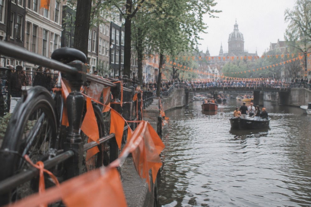 A canal in Amsterdam decorated with orange bunting for King's Day