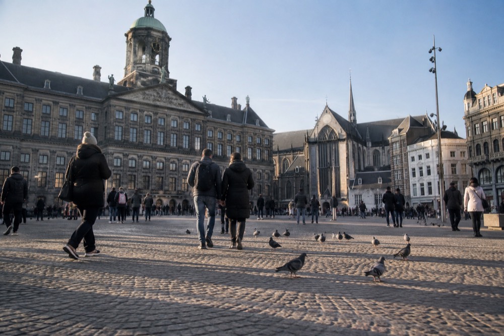 Brick facades and a quiet canal edge beside Dam Square