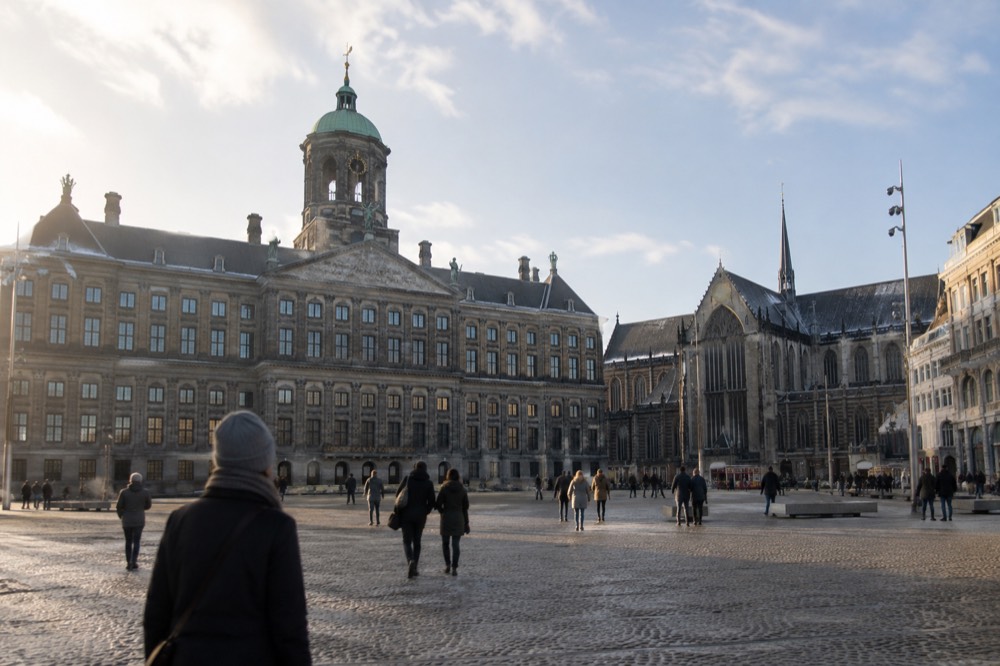 Brick facades and a quiet canal edge beside Dam Square
