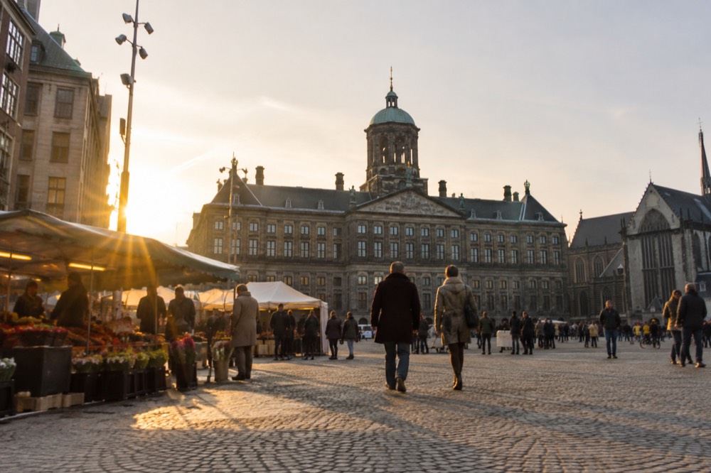 A quiet corner of Dam Square with trees overhanging the water