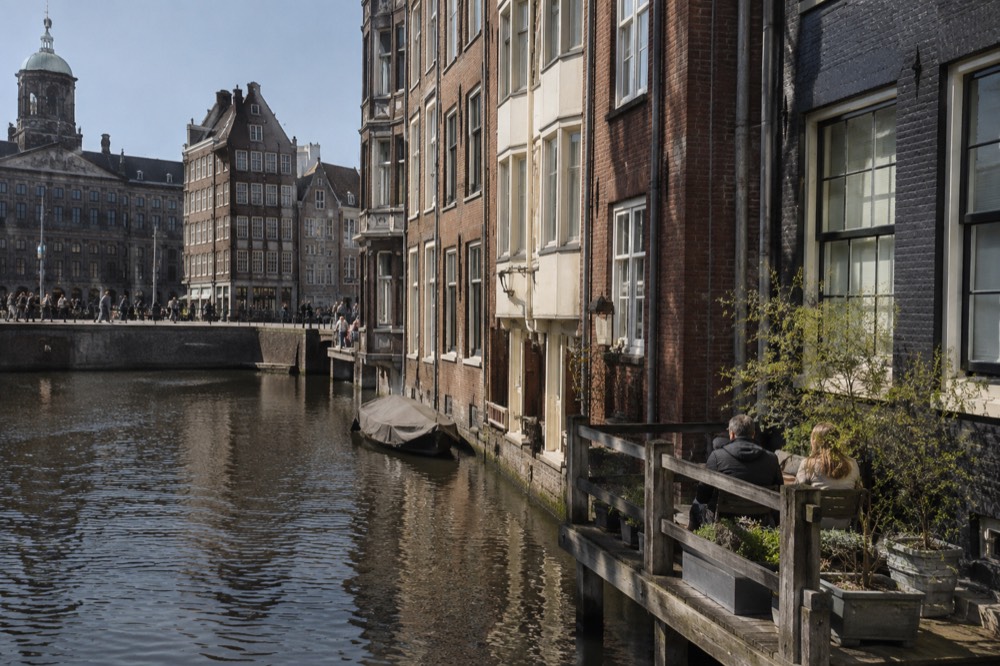 Brick facades and a quiet canal edge beside Dam Square