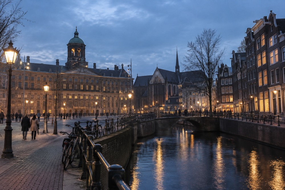 Brick facades and a quiet canal edge beside Dam Square