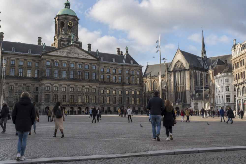 People walking past Dam Square, seen from across the street