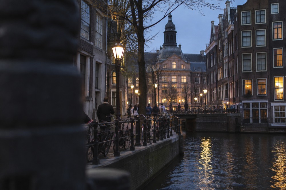 Brick facades and a quiet canal edge beside Dam Square