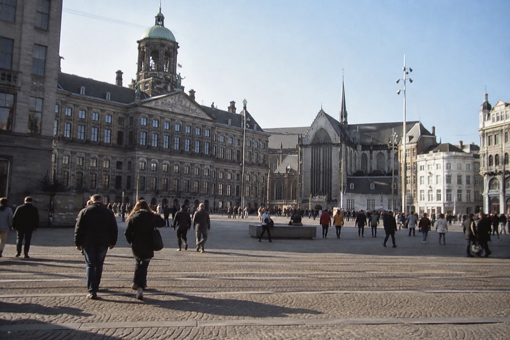 People walking past Dam Square, seen from across the street