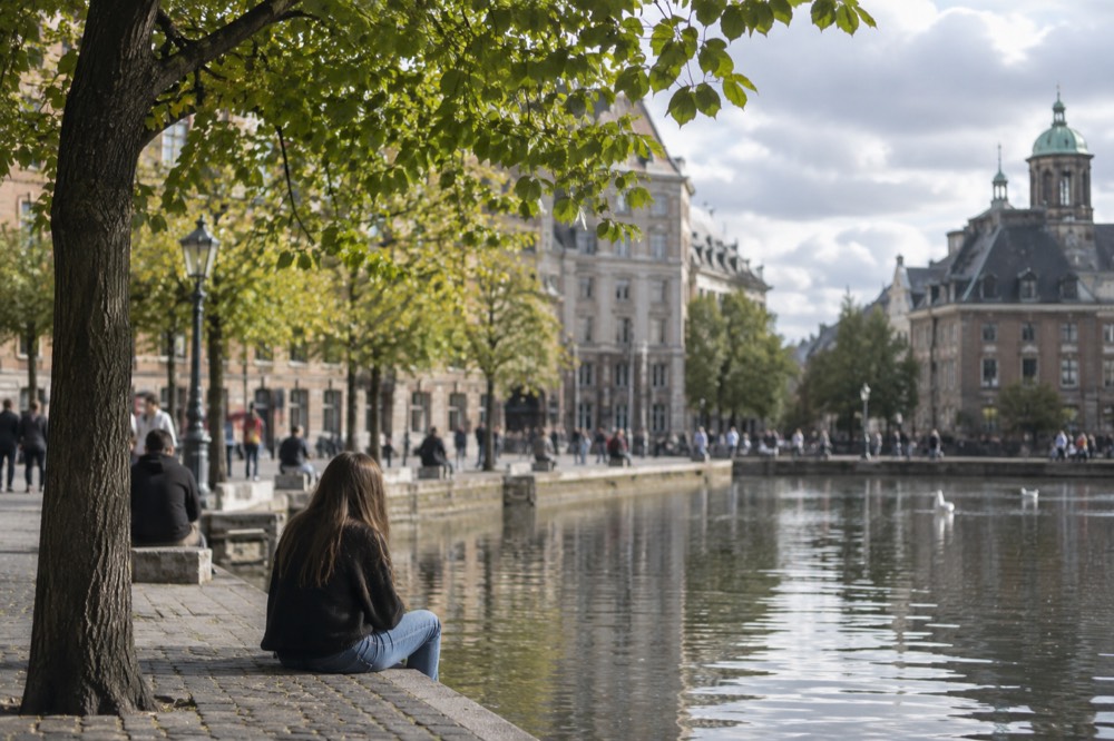 A quiet corner of Dam Square with trees overhanging the water