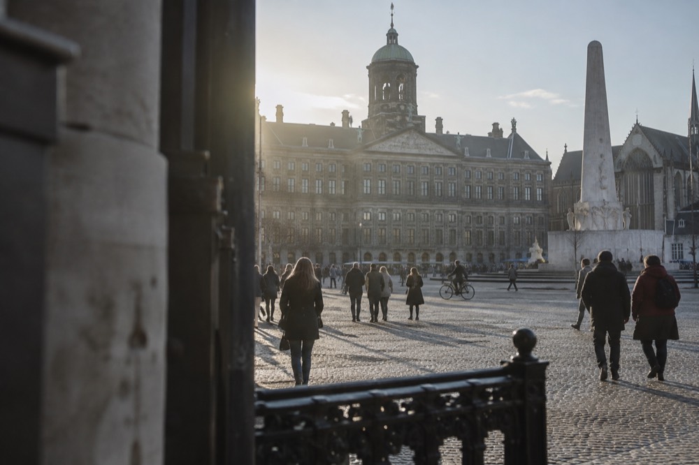 People walking past Dam Square, seen from across the street