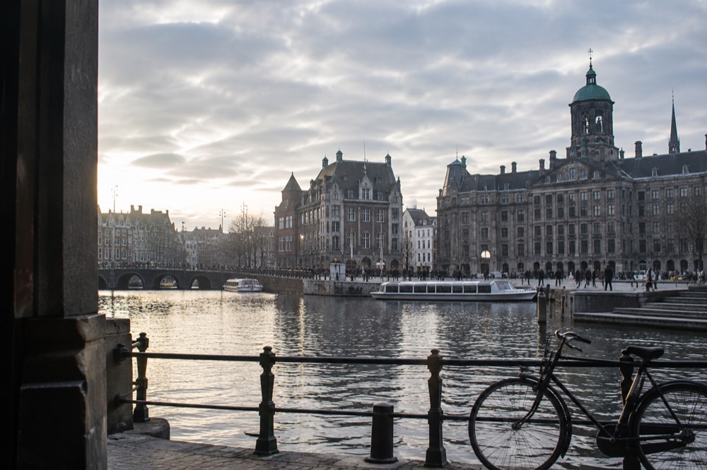 The waterfront near Dam Square under a broad grey northern sky