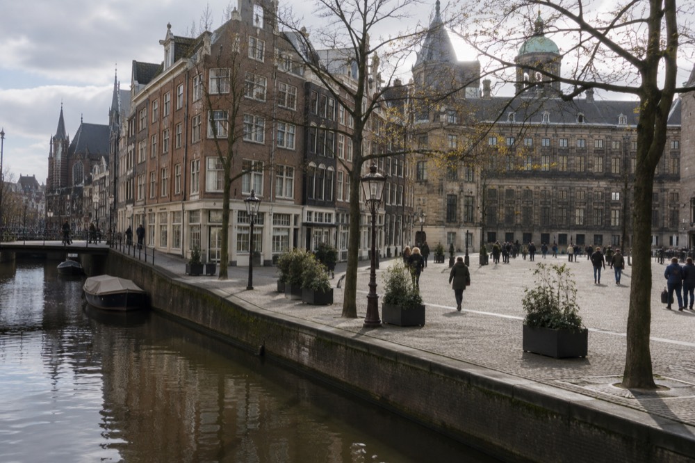 Brick facades and a quiet canal edge beside Dam Square