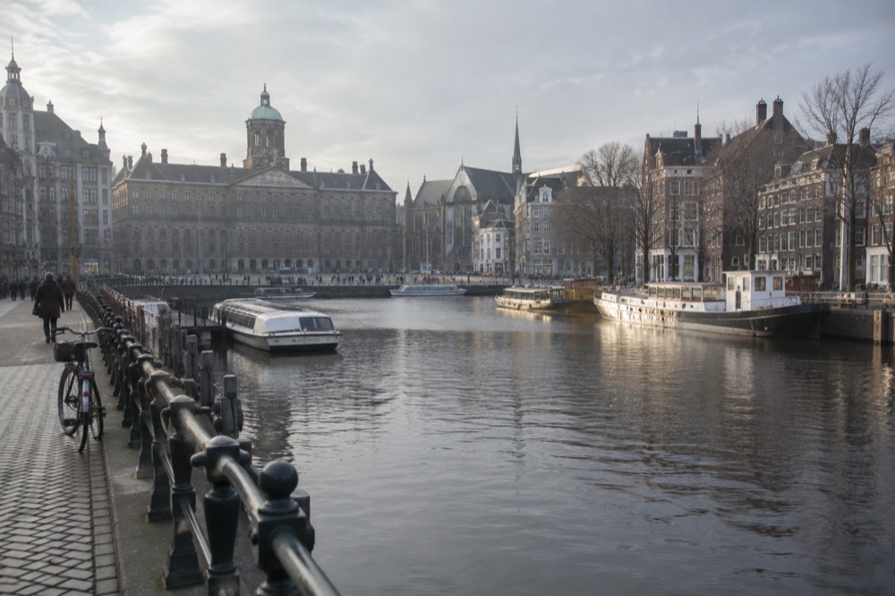The waterfront near Dam Square under a broad grey northern sky