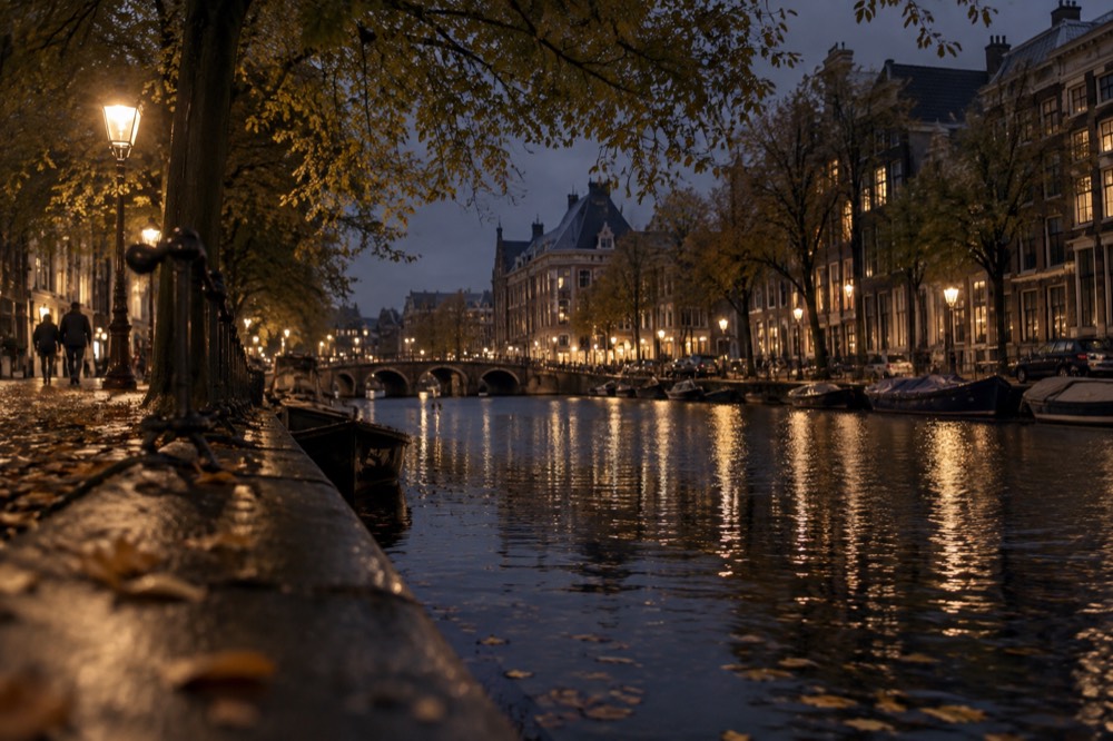 A quiet corner of Dam Square with trees overhanging the water