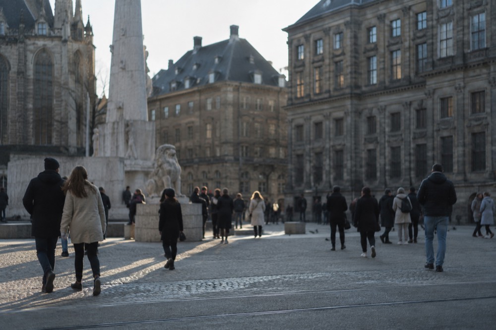 People walking past Dam Square, seen from across the street