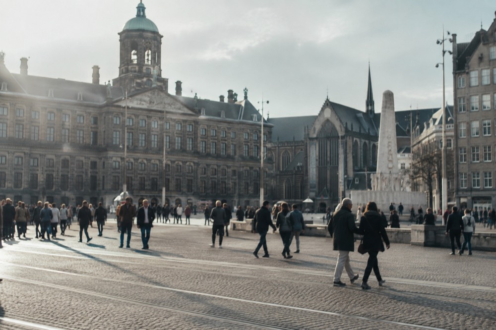 People walking past Dam Square, seen from across the street