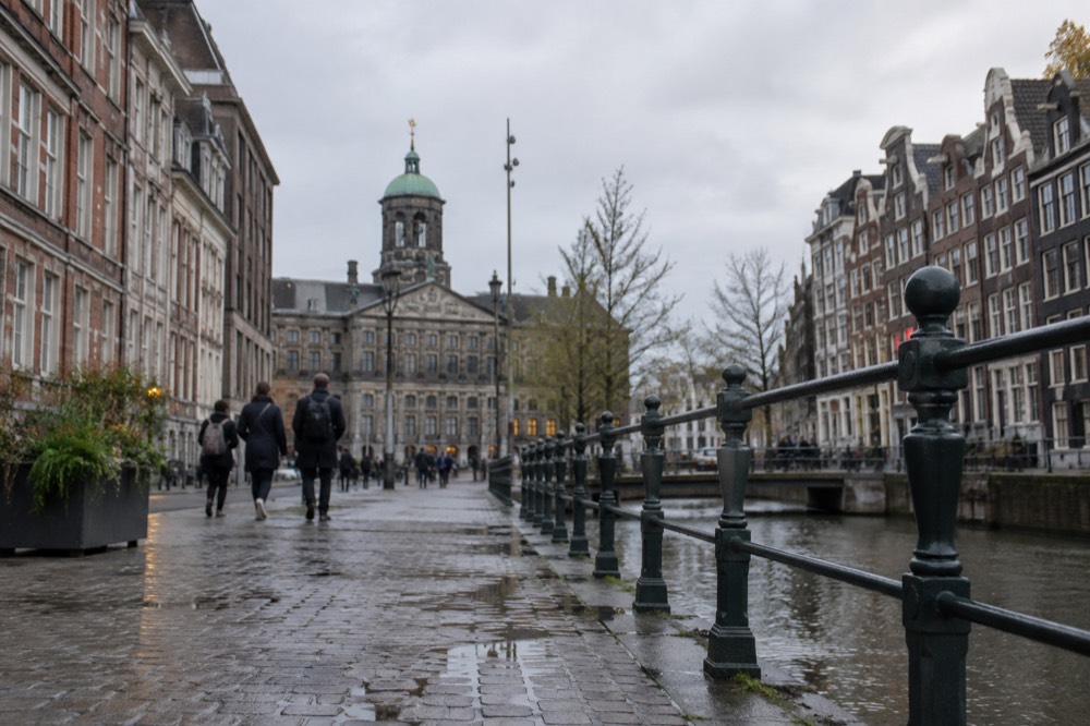 Brick facades and a quiet canal edge beside Dam Square